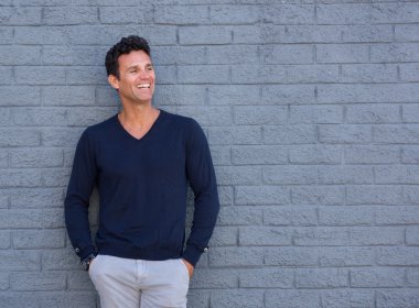 Yaşlı adamın gri duvara gülümseyen uygun