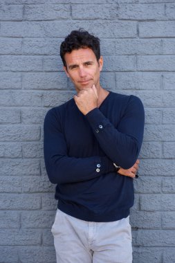 Dalgın adam çene üzerinde el ile ayakta