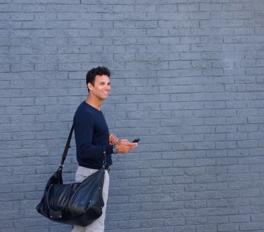 Cep telefonu ve paket ile yürüyen çekici adam