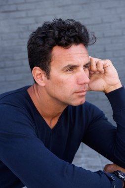 Yakışıklı adam oturuyor ve düşünme kadar yakın