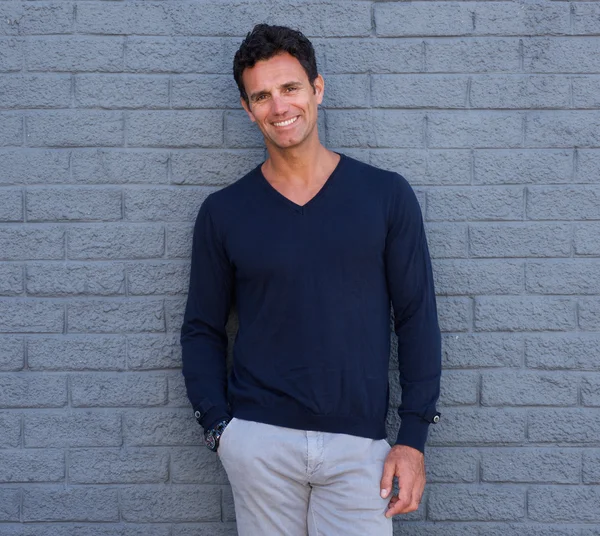 Handsome confident man smiling against gray wall — Stock Photo, Image