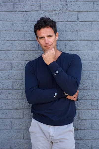 Dalgın adam çene üzerinde el ile ayakta