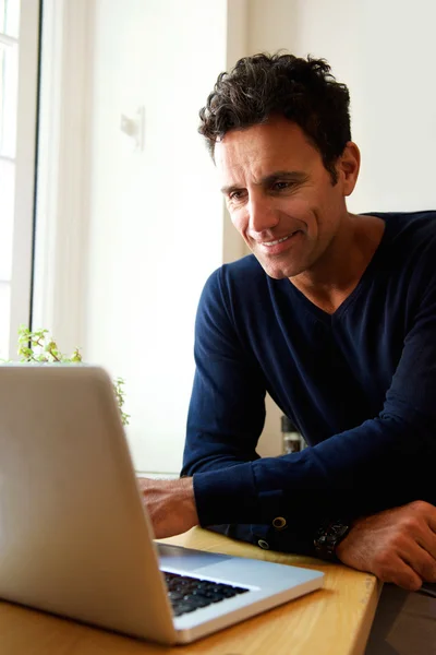 Μέσης ηλικίας τύπος χρησιμοποιεί φορητό υπολογιστή στο σπίτι — Φωτογραφία Αρχείου
