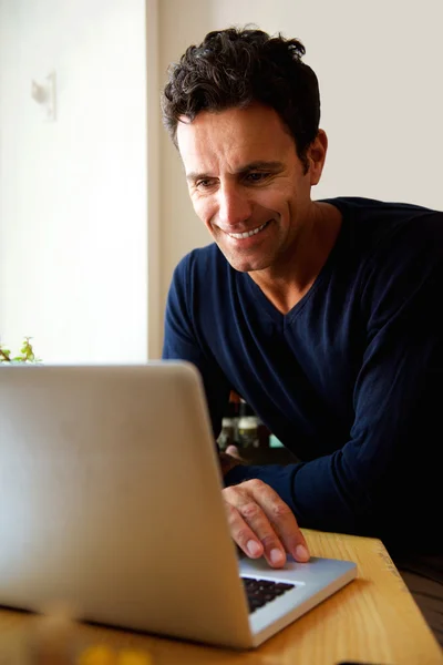 Homem de meia-idade usando laptop em casa — Fotografia de Stock