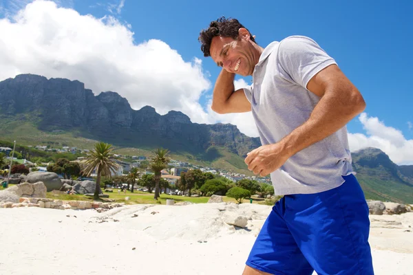 Мужчина средних лет прогуливается по пляжу — стоковое фото