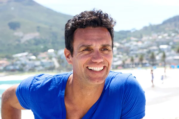 Orta yaşlı adam gülümsüyor. 