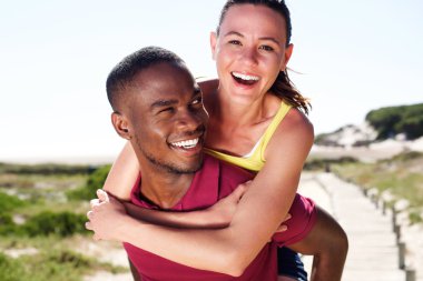 Mutlu genç adam çekici kız sırtında taşıyan