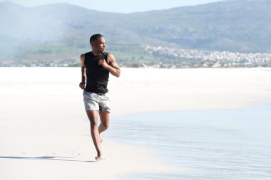 Sahilde koşan sağlıklı genç adam