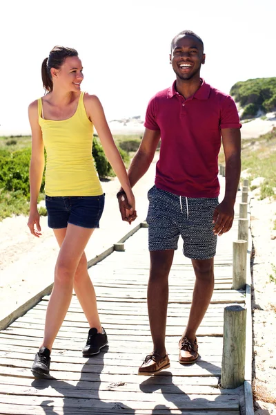 Felice giovane coppia a piedi dalla spiaggia — Foto Stock