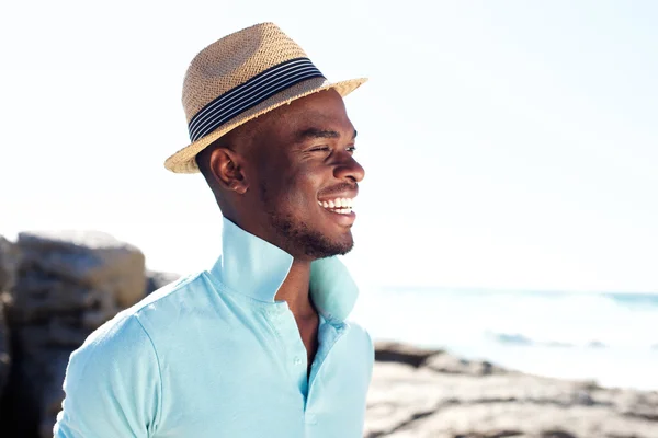 Bonito jovem sorrindo na praia — Fotografia de Stock