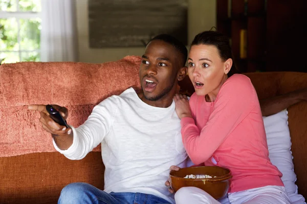 Asustada joven pareja viendo la televisión — Foto de Stock