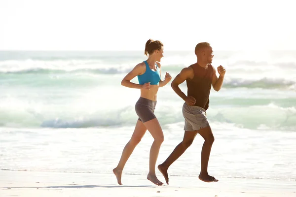 Pareja de fitness corriendo por el mar — Foto de Stock