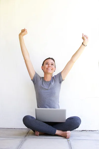 Jonge vrouw met laptop vieren — Stockfoto