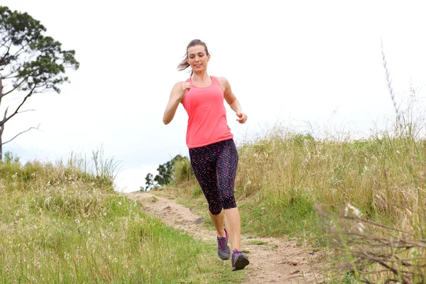 Sportieve vrouw lopen op vuil weg — Stockfoto