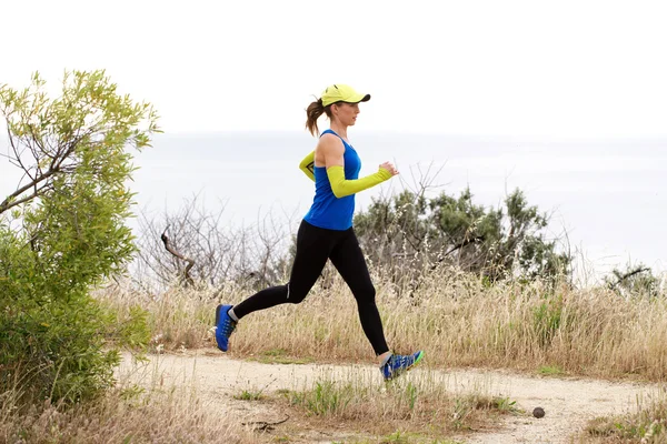 Sporty woman running on dirt path — Stock Photo, Image