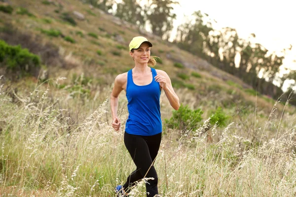 Sorridente donna attiva trail running — Foto Stock