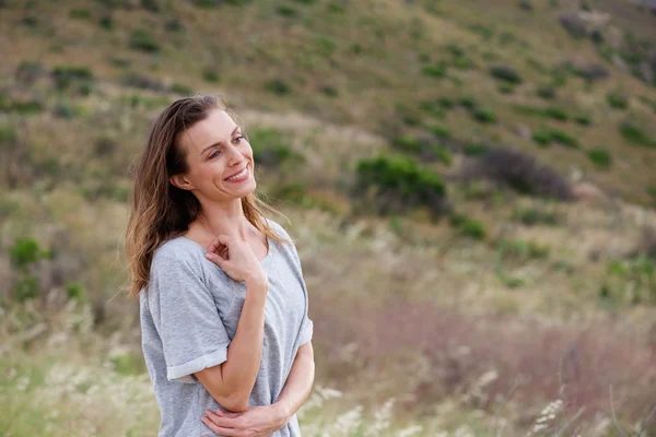 Smiling woman standing in nature — Stock Photo, Image