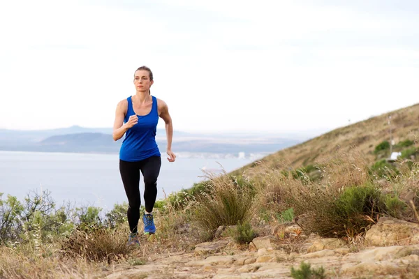 Woman running up hill — Stock Photo, Image