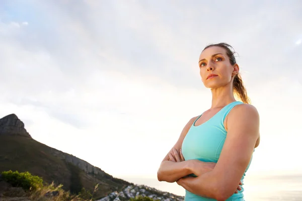 Femme sportive avec les bras croisés fixant — Photo