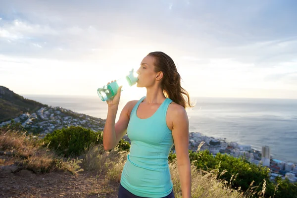 Mulher atlética bebendo água após o treino — Fotografia de Stock