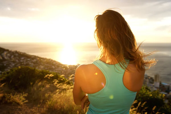 Sportieve vrouw achter kijken naar de zonsondergang — Stockfoto