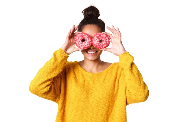 Junge Frau bedeckt ihre Augen mit Donuts — Stockfoto