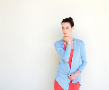 Beyaz duvara karşı duran ciddi kadın