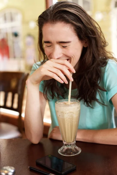 Junge Frau lacht mit Milchshake — Stockfoto