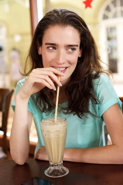 Giovane donna che beve frullato in un caffè — Foto Stock