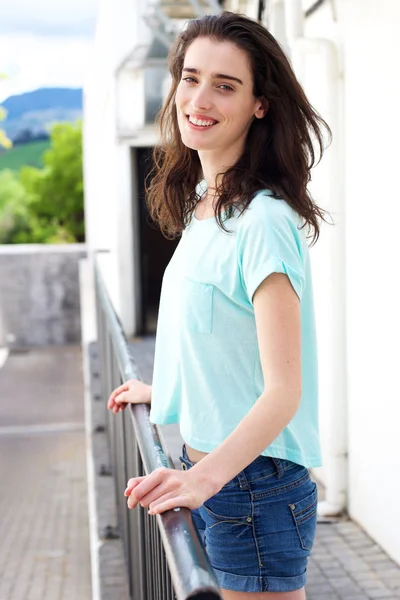 Junge Frau mit lächelnden Händen am Geländer — Stockfoto