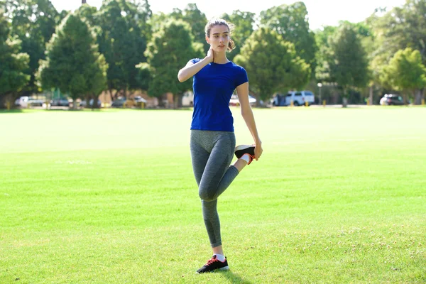 Sportliche Frau streckt sich im Feld — Stockfoto