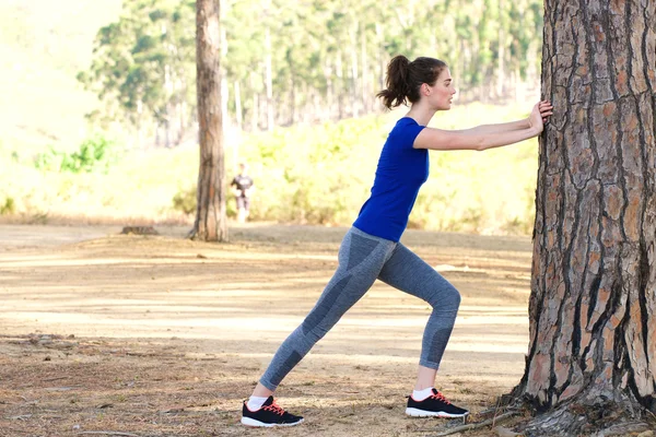 Sportliche Frau fährt gegen Baum — Stockfoto