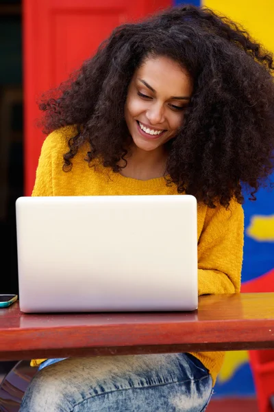 Sorrindo mulher negra usando laptop no café — Fotografia de Stock