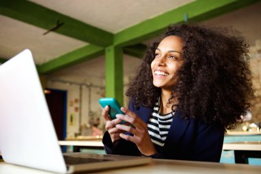 Cep telefonu ile kafede neşeli genç bayan