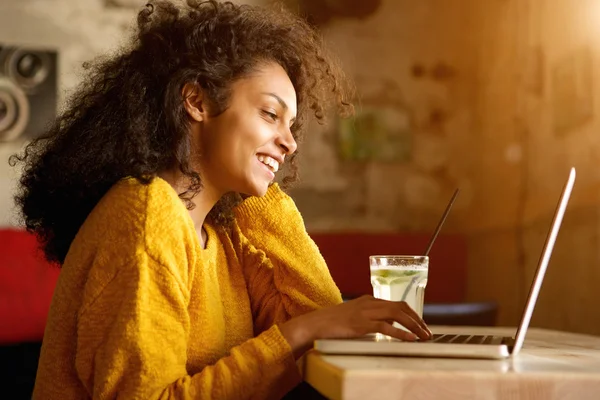 Jovem alegre trabalhando no laptop no café — Fotografia de Stock