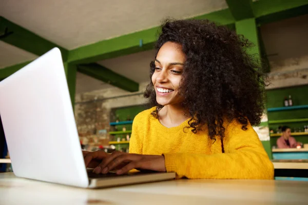 Dizüstü bilgisayarda çalışma gülümseyen genç bayan