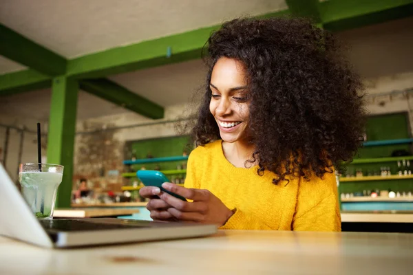 Vrolijke jonge vrouw met behulp van mobiele telefoon — Stockfoto