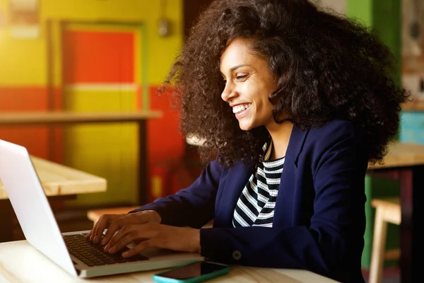 Allegro giovane donna africana utilizzando il computer portatile — Foto Stock