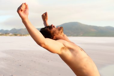 Gömleksiz genç adam kollarını kaldırdı