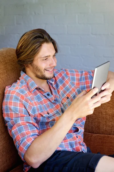 Junger Mann genießt Spiel auf digitalem Tablet — Stockfoto