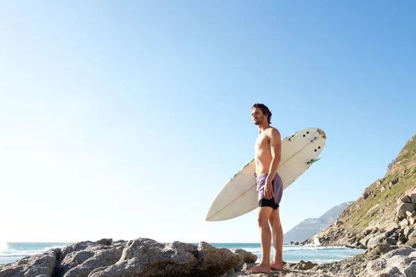 Aantrekkelijke jonge man permanent op strand — Stockfoto