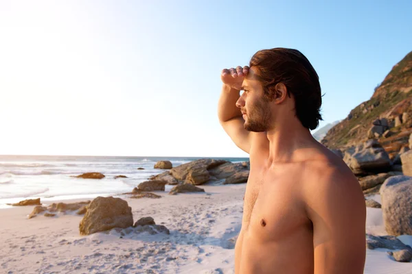 Fiatal férfi állandó strandon — Stock Fotó