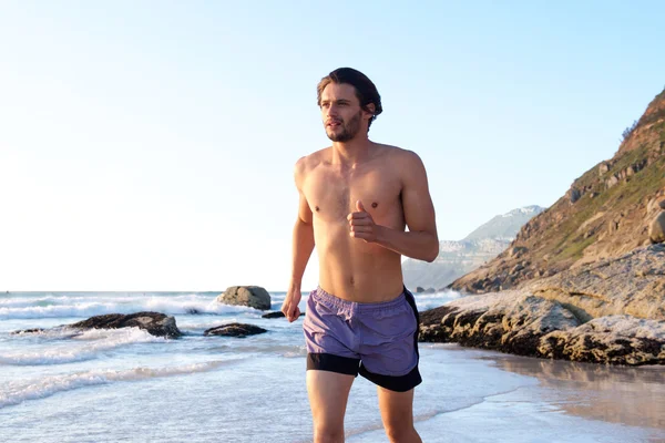 Mannelijke atleet op het strand — Stockfoto