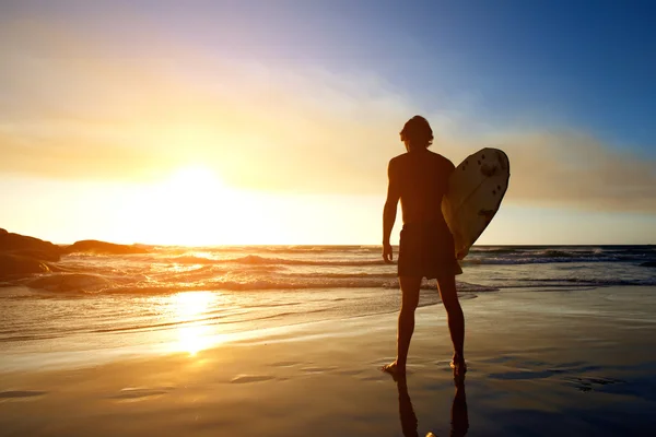 Surfer kijken naar de zonsondergang op het strand — Stockfoto