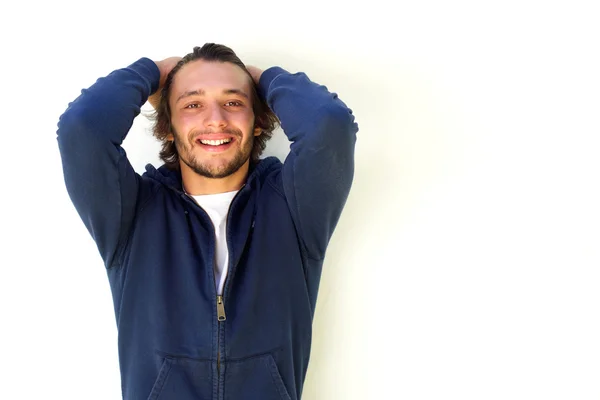 Jonge man met de handen in het haar te glimlachen — Stockfoto