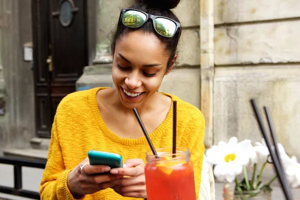 Happy young african woman sitting at cafe — Stock Photo, Image