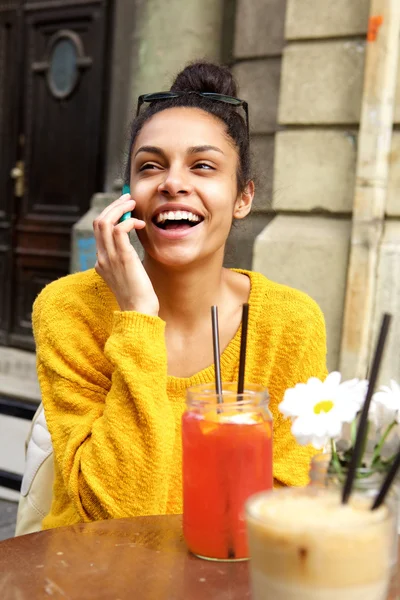 Веселая женщина в кафе на открытом воздухе с помощью мобильного телефона — стоковое фото