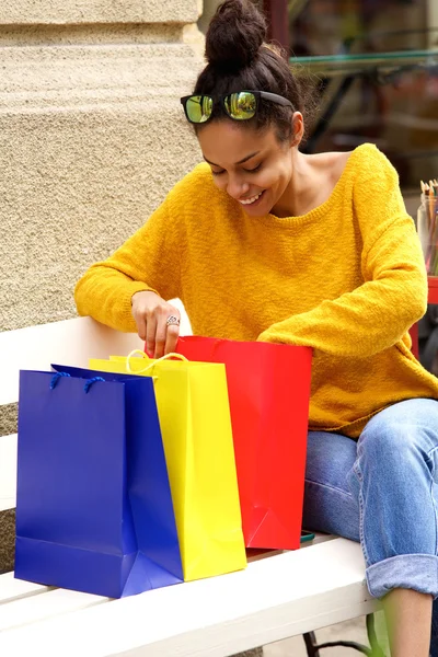 Szczęśliwa młoda kobieta, patrząc na torby na zakupy — Zdjęcie stockowe