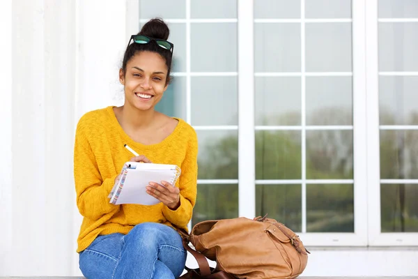 Bella giovane donna che scrive nel libro — Foto Stock