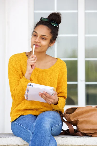 Thoughtful woman sitting outside with book — Stock Photo, Image